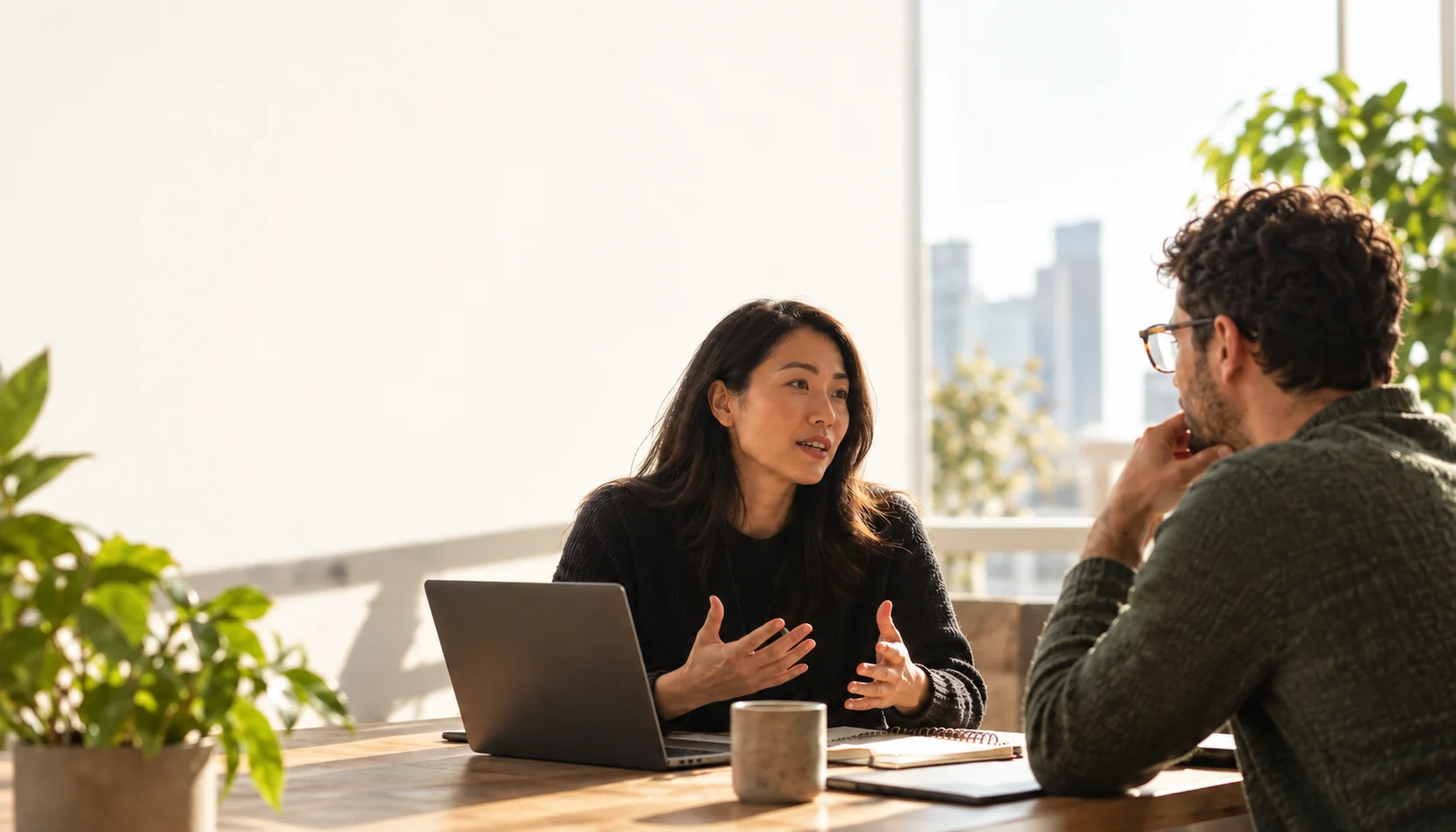Two colleagues sharing a thoughtful conversation in a sunlit office
